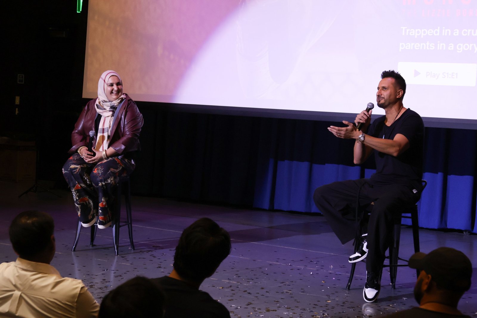 Asim Khan moderating a Q&A with director Lena Khan on stage