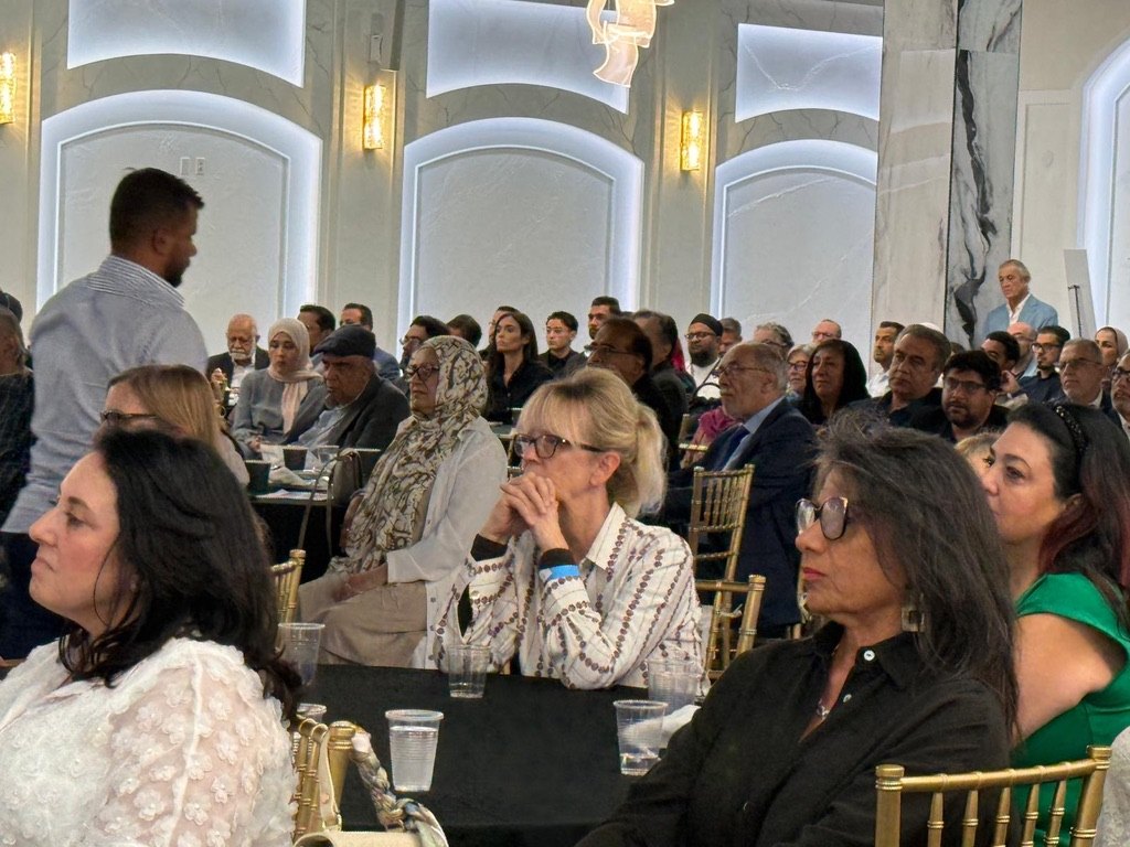Guests seated at banquet tables listening to the program