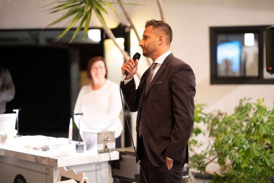Asim Khan working a room with a handheld microphone