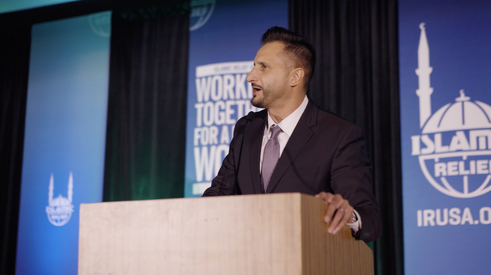 Asim Khan emceeing an Islamic Relief USA benefit at the lectern