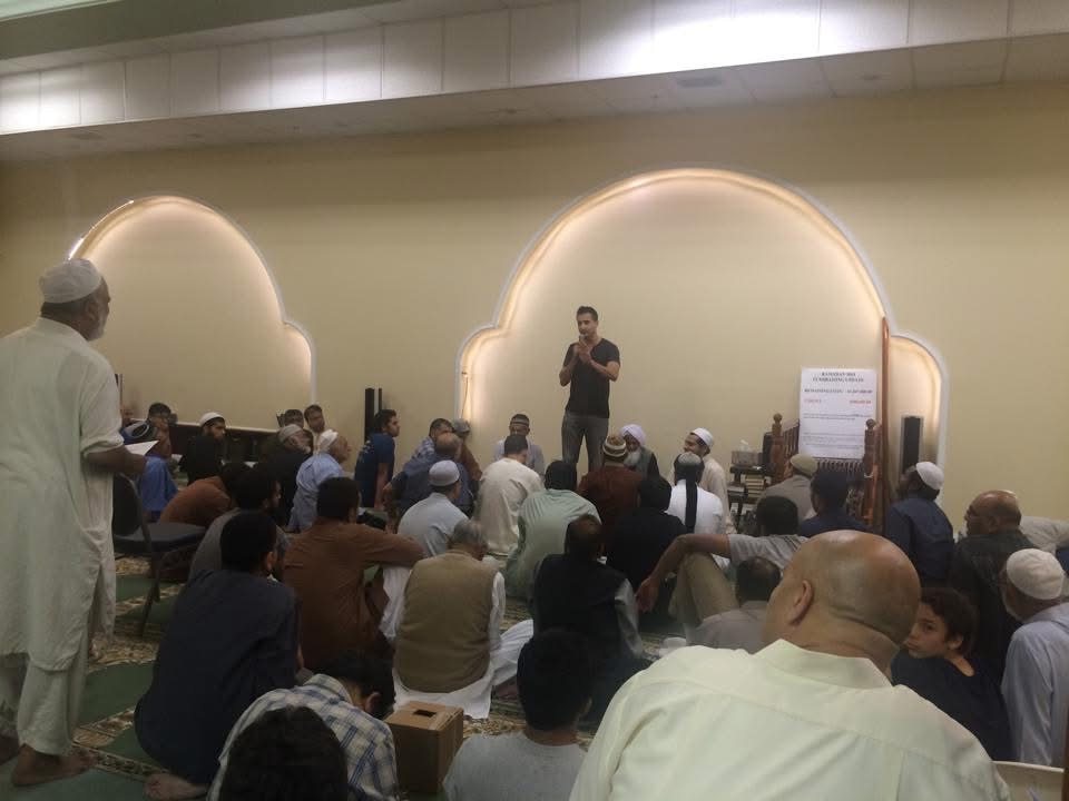 Asim Khan raising money in front of a seated congregation