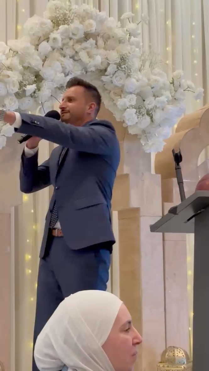 Asim Khan on stage with a microphone